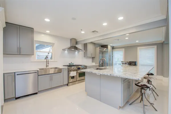 a large kitchen with stainless steel appliances granite countertop a sink and cabinets