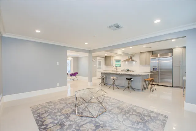 a living room with furniture and a dining table with kitchen view