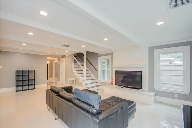 a living room with furniture a flat screen tv and a fireplace