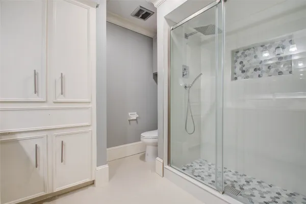 a bathroom with a granite countertop shower and a toilet