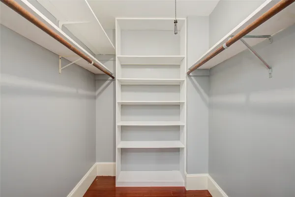 a view of walk in closet with empty racks