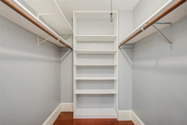 a view of walk in closet with empty racks
