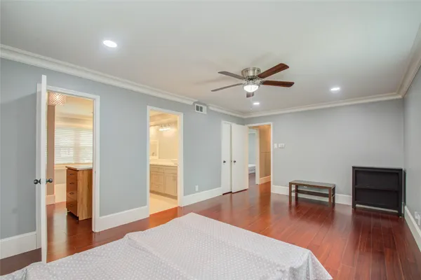 a living room with wooden floor and a ceiling fan