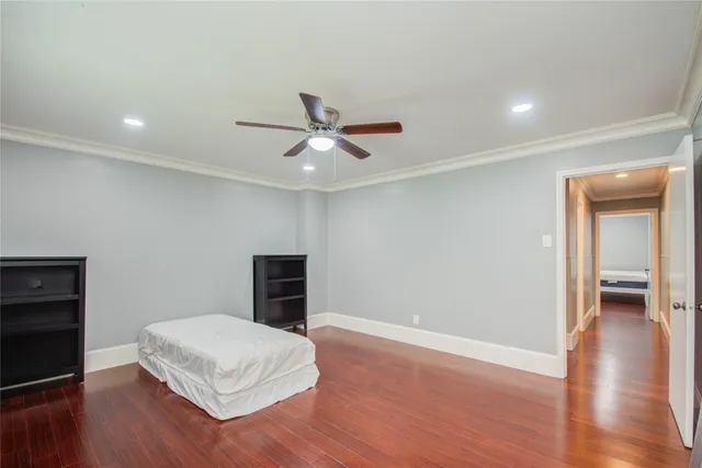 a living room with a wooden floor and a ceiling fan