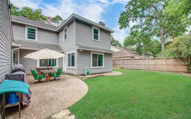 a backyard of a house with table and chairs