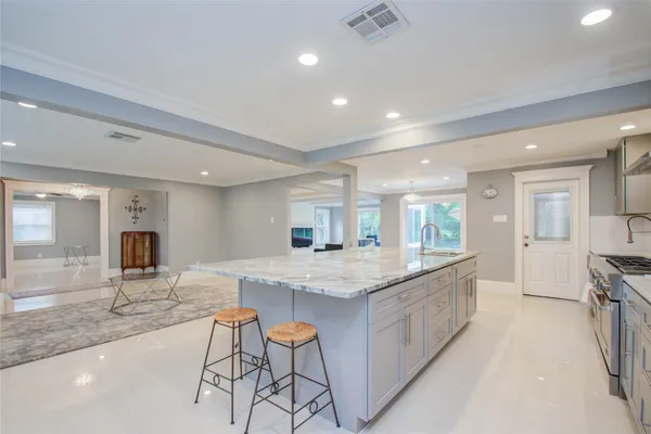 a large kitchen with kitchen island a large counter top