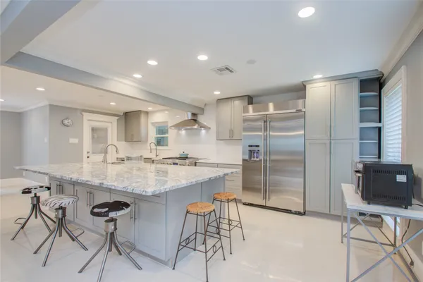 a kitchen with center island cabinets and stainless steel appliances
