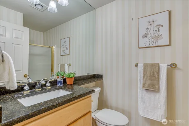 a bathroom with a granite countertop sink and a mirror