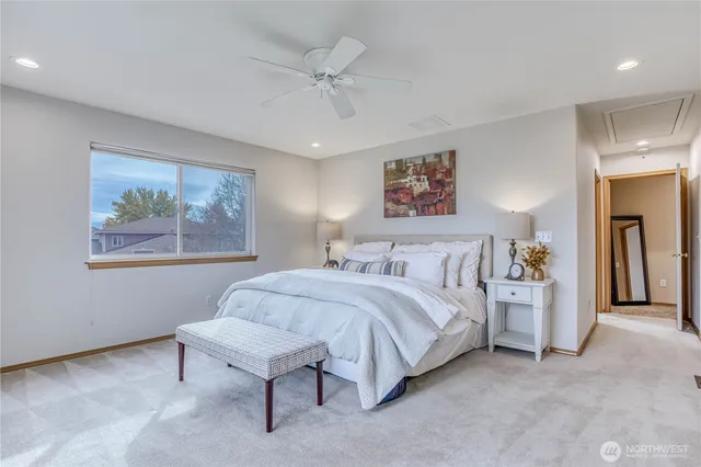 a spacious bedroom with a bed and a painting on the wall