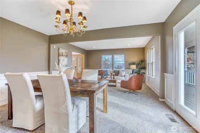 a view of a dining room with furniture and chandelier