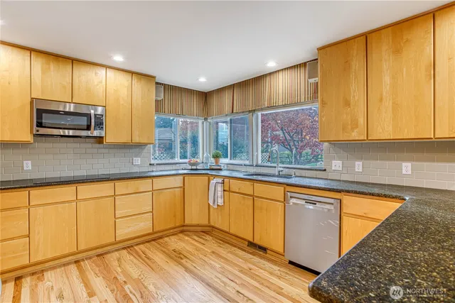 a kitchen with stainless steel appliances granite countertop wooden cabinets a sink and dishwasher