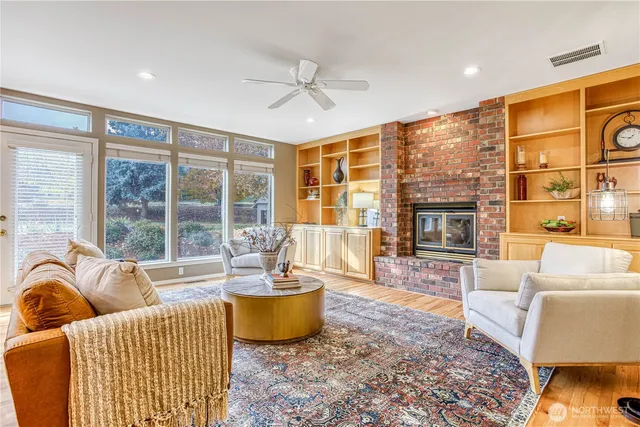 a living room with furniture a fireplace and a floor to ceiling window