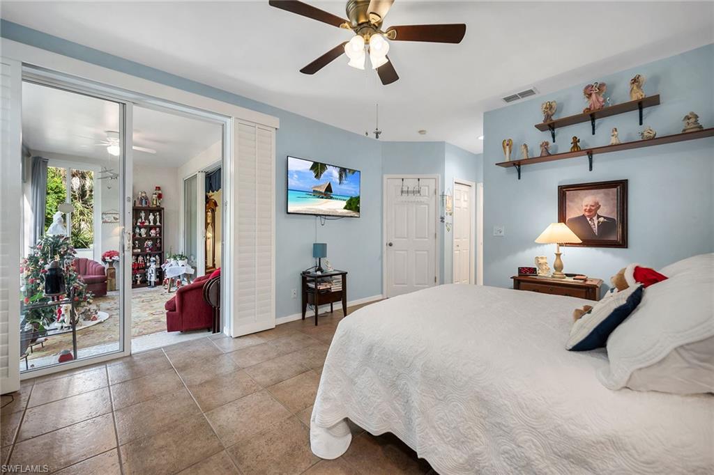 3755 Fieldstone Boulevard, Unit 1203 Naples, FL 34109 - Photo 17 of 50 a bedroom with a bed and view of living room