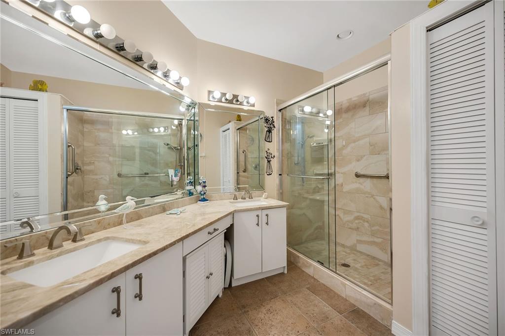3755 Fieldstone Boulevard, Unit 1203 Naples, FL 34109 - Photo 18 of 50 a bathroom with a shower sink double and mirror
