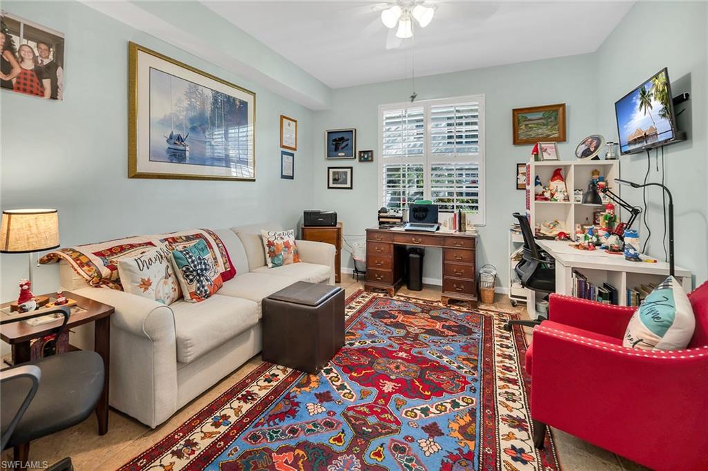 3755 Fieldstone Boulevard, Unit 1203 Naples, FL 34109 - Photo 20 of 50 a living room with furniture and a flat screen tv