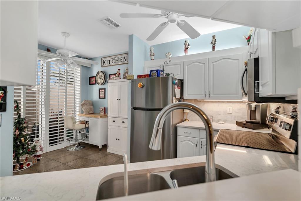 3755 Fieldstone Boulevard, Unit 1203 Naples, FL 34109 - Photo 2 of 50 a kitchen with refrigerator and stove