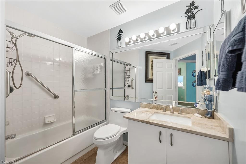 3755 Fieldstone Boulevard, Unit 1203 Naples, FL 34109 - Photo 22 of 50 a bathroom with a sink a toilet a mirror and shower