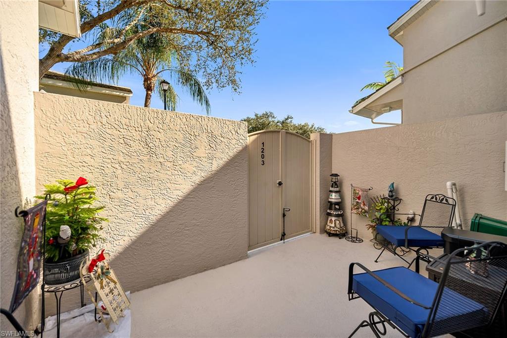 3755 Fieldstone Boulevard, Unit 1203 Naples, FL 34109 - Photo 24 of 50 a balcony with table and chairs