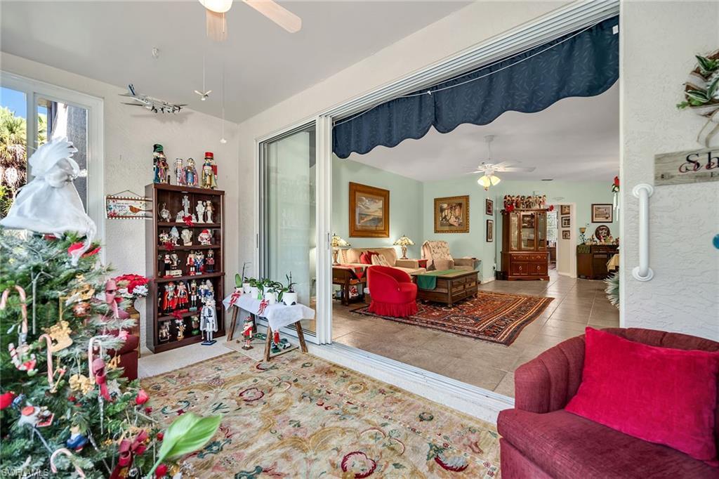 3755 Fieldstone Boulevard, Unit 1203 Naples, FL 34109 - Photo 30 of 50 a living room with furniture and flowers