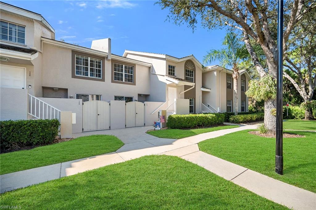3755 Fieldstone Boulevard, Unit 1203 Naples, FL 34109 - Photo 32 of 50 a front view of a house with a yard