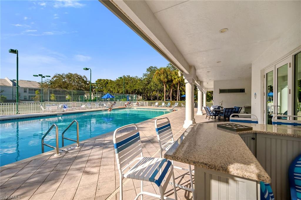 3755 Fieldstone Boulevard, Unit 1203 Naples, FL 34109 - Photo 39 of 50 a view of swimming pool with outdoor seating and plants