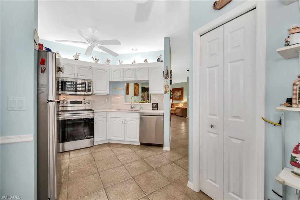 3755 Fieldstone Boulevard, Unit 1203 Naples, FL 34109 - Photo 4 of 50 a kitchen with stainless steel appliances a refrigerator sink and microwave