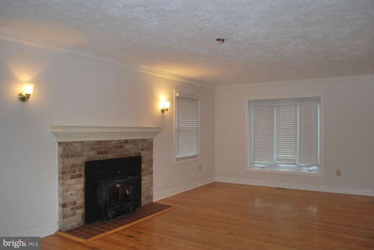 334 Old Joppa Road Fallston, MD 21047 - Photo 13 of 20 a view of empty room with wooden floor and fireplace