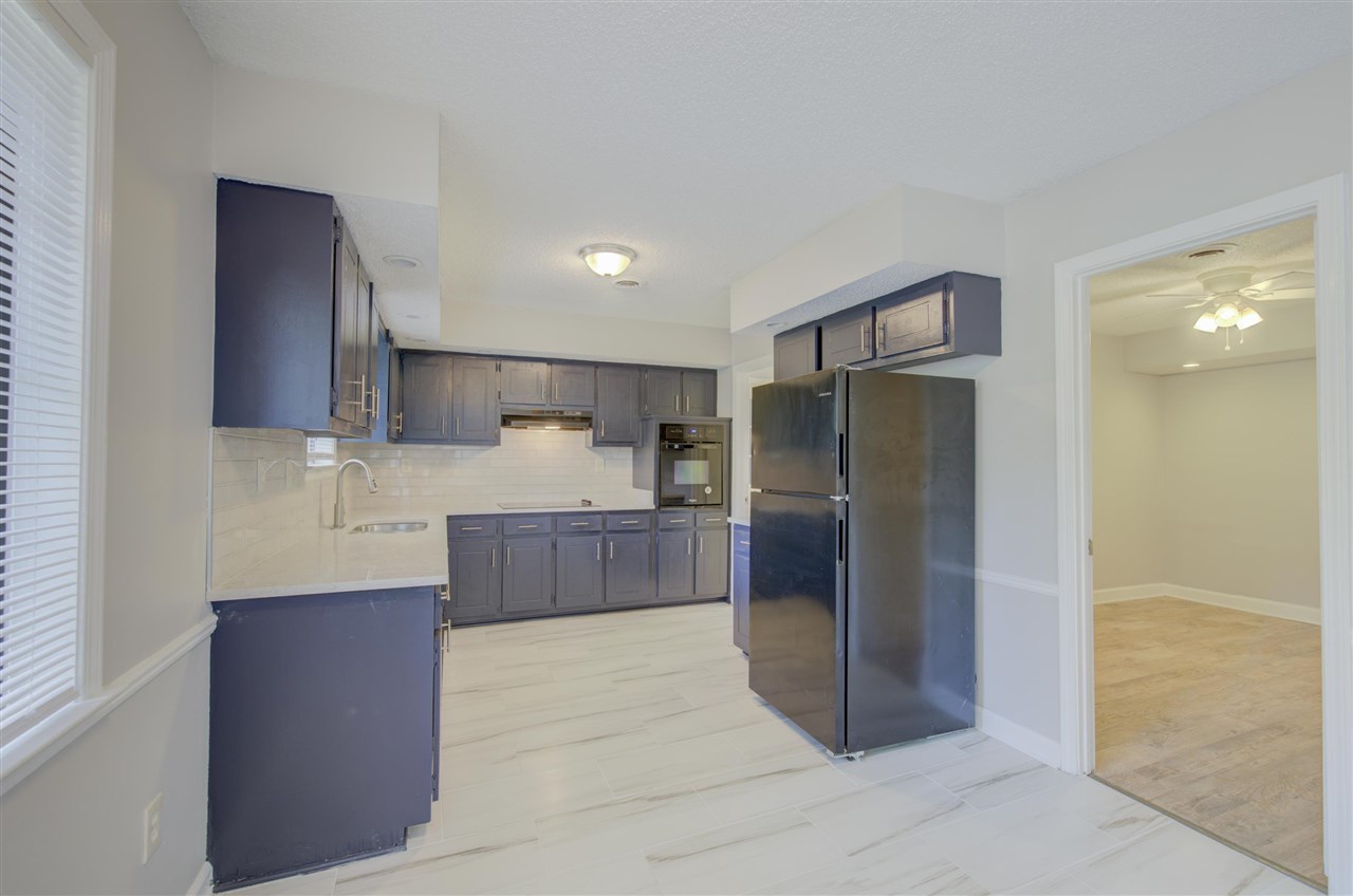 7024 Rockingham Road Memphis, TN 38125 - Photo 7 of 18 a kitchen with stainless steel appliances granite countertop a refrigerator and a sink