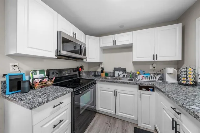 a dining room with wooden floor a chandelier a wooden table and chairs