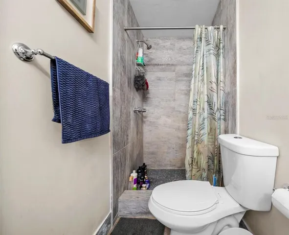a bathroom with a toilet and a shower