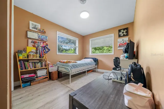 a bed sitting in a bedroom next to a window