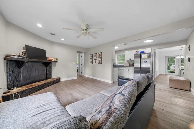 a living room with stainless steel appliances kitchen island a large counter top and a refrigerator