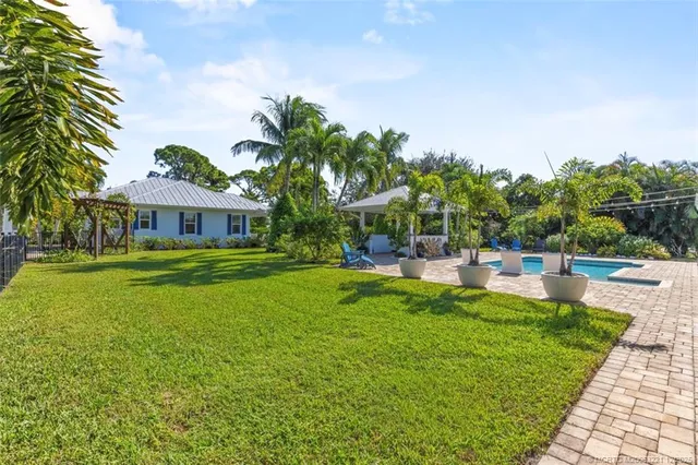 a view of a house with a yard and potted plants