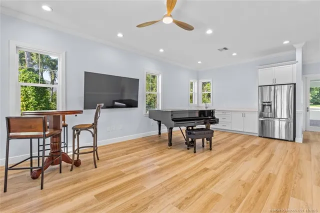 an aerial view of a residential houses with outdoor space and trees all around