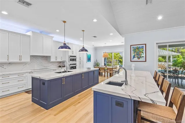 a view of a kitchen with kitchen island a sink stainless steel appliances and cabinets