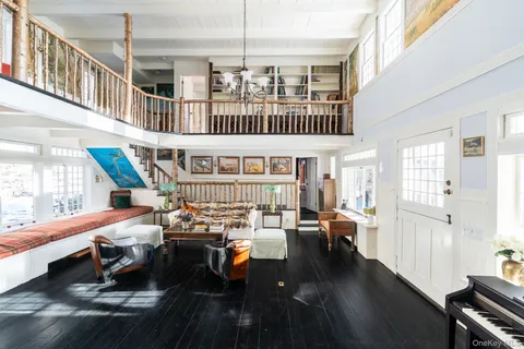 a living room with furniture pool table and wooden floor