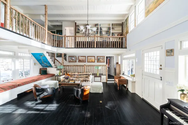 a living room with furniture pool table and wooden floor