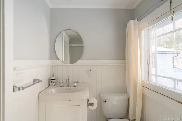 a bathroom with a toilet sink and mirror