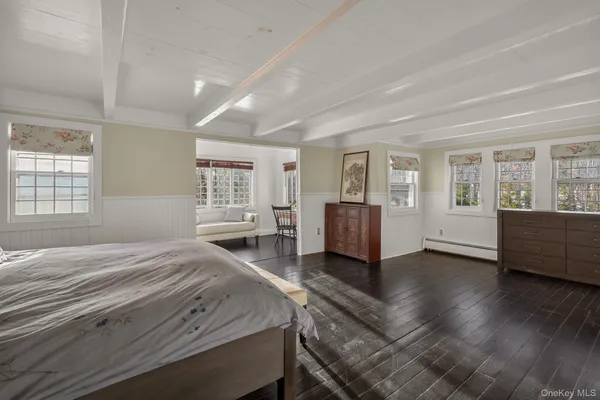 a spacious bedroom with a balcony a bed and wooden floor