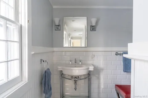 a bathroom with a sink a mirror and a window
