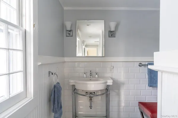a bathroom with a sink a mirror and a window