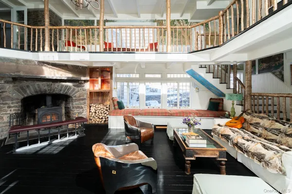 a roof deck with couches table and chairs with wooden floor