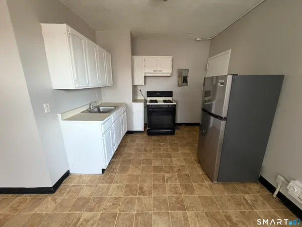 a kitchen with granite countertop a refrigerator and a sink