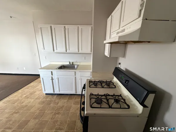 a kitchen with a stove and a white cabinet