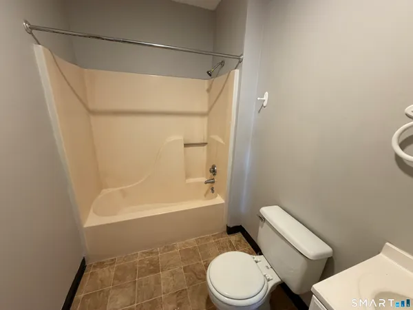 a white toilet sitting next to a bath tub