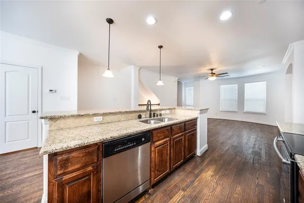 a kitchen with granite countertop cabinets stainless steel appliances and wooden floor