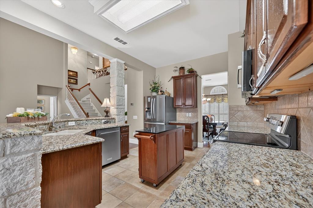 1371 San Rafael Drive Rockwall, TX 75087 - Photo 17 of 35 a kitchen with stainless steel appliances granite countertop a sink stove and refrigerator