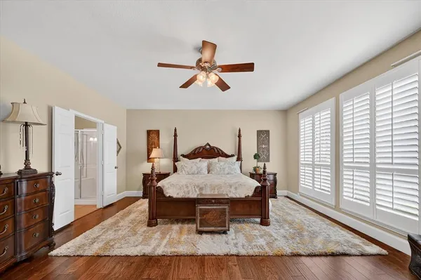 a spacious bedroom with a bed and wooden floor