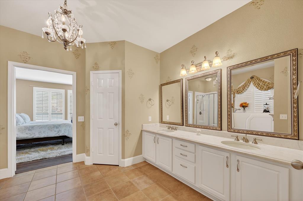 1371 San Rafael Drive Rockwall, TX 75087 - Photo 25 of 35 a spacious bathroom with a granite countertop sink a mirror a shower and a bathtub