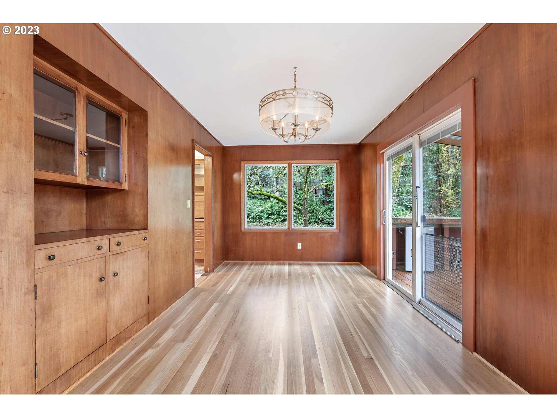 2435 Southwest Dakota Street Portland, OR 97239 - Photo 14 of 47 a open kitchen with wooden floors a chandelier a wooden table and chairs